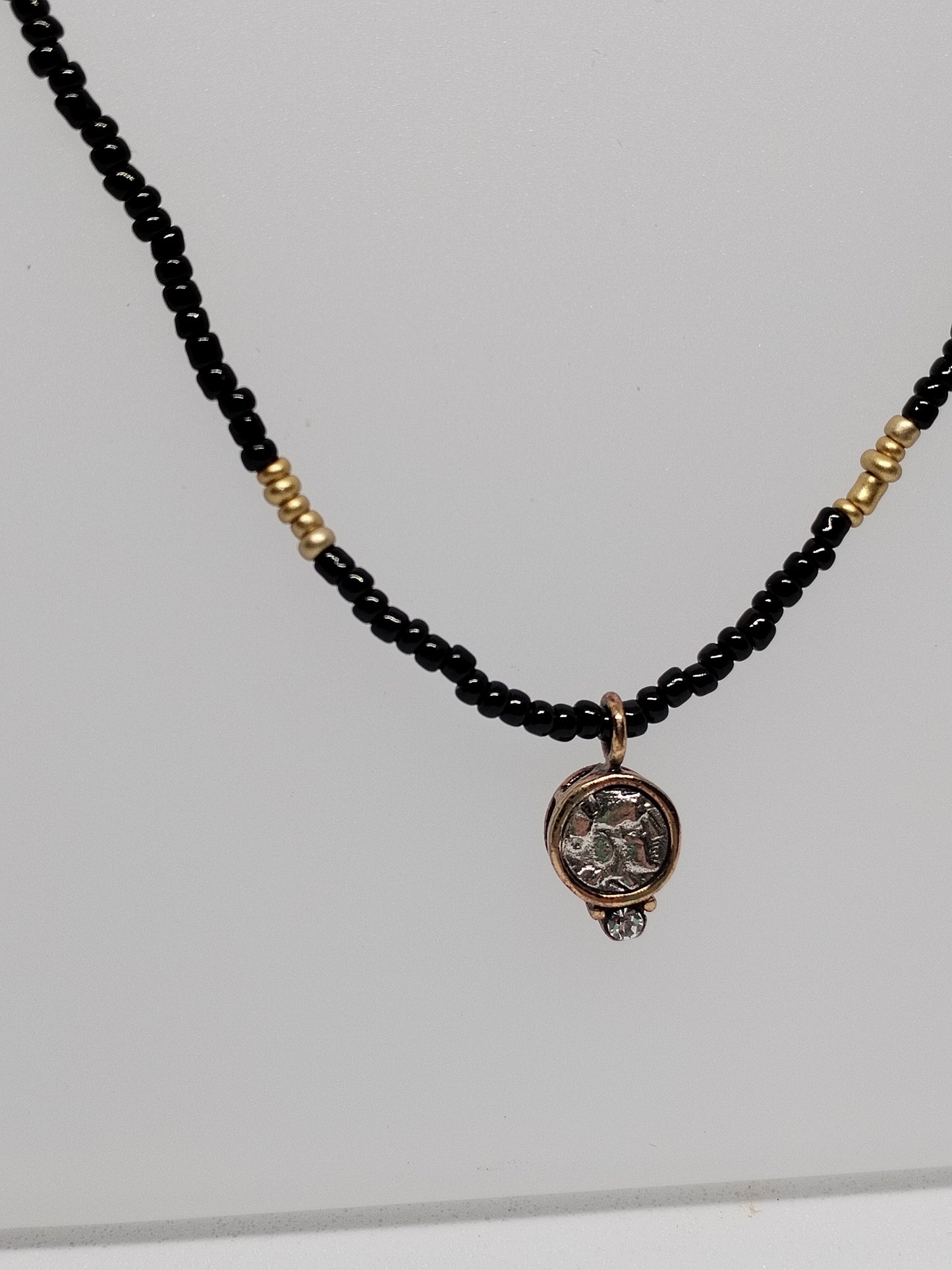 Black & gold beaded necklace with vintage pendant